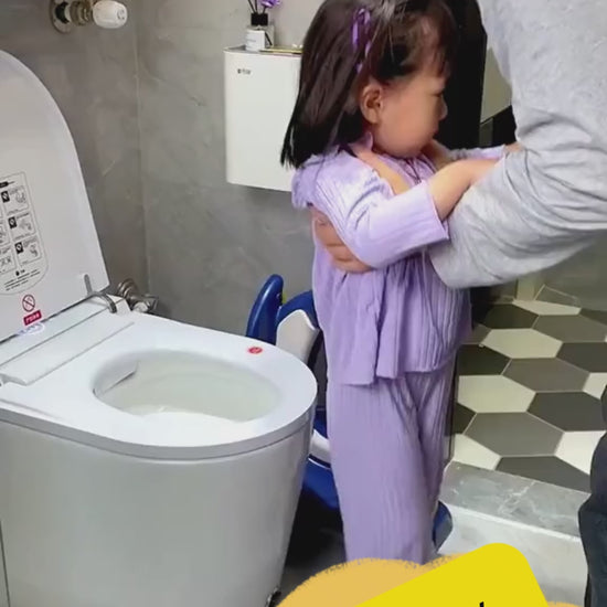 "A father helping a young toddler girl in the bathroom with a children potty training toilet seat ladder."