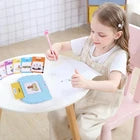 Zalviro – A young child sitting carefully at a white table using the interactive talking card device during an early education study session.