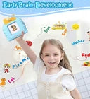 Zalviro – A young girl smiling and holding up a blue interactive flash card device during a cheerful household playroom session..